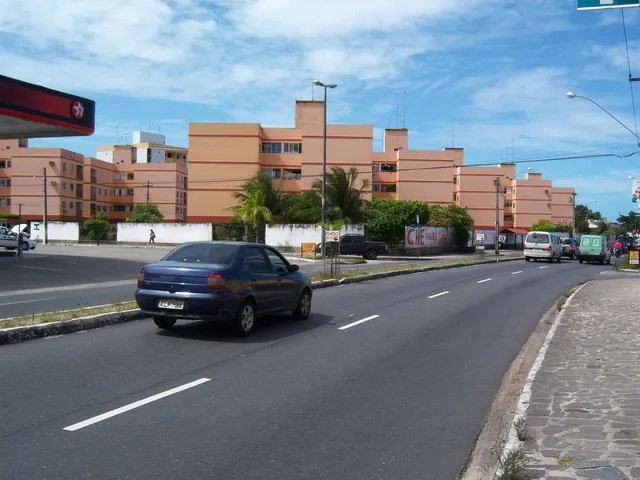 Rua do bairro dos Bancários com conjuntos residenciais ao fundo