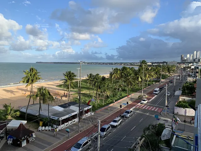 Avenida Almirante Tamandaré vista do alto em Tambaú, com coqueiros, a praia e as falésias do Cabo Branco ao fundo