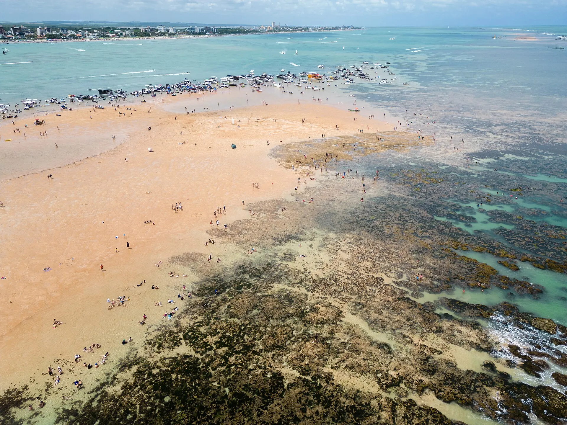 Banco de Areia Vermelha visto do alto na maré baixa, com banhistas na areia clara e recifes em volta