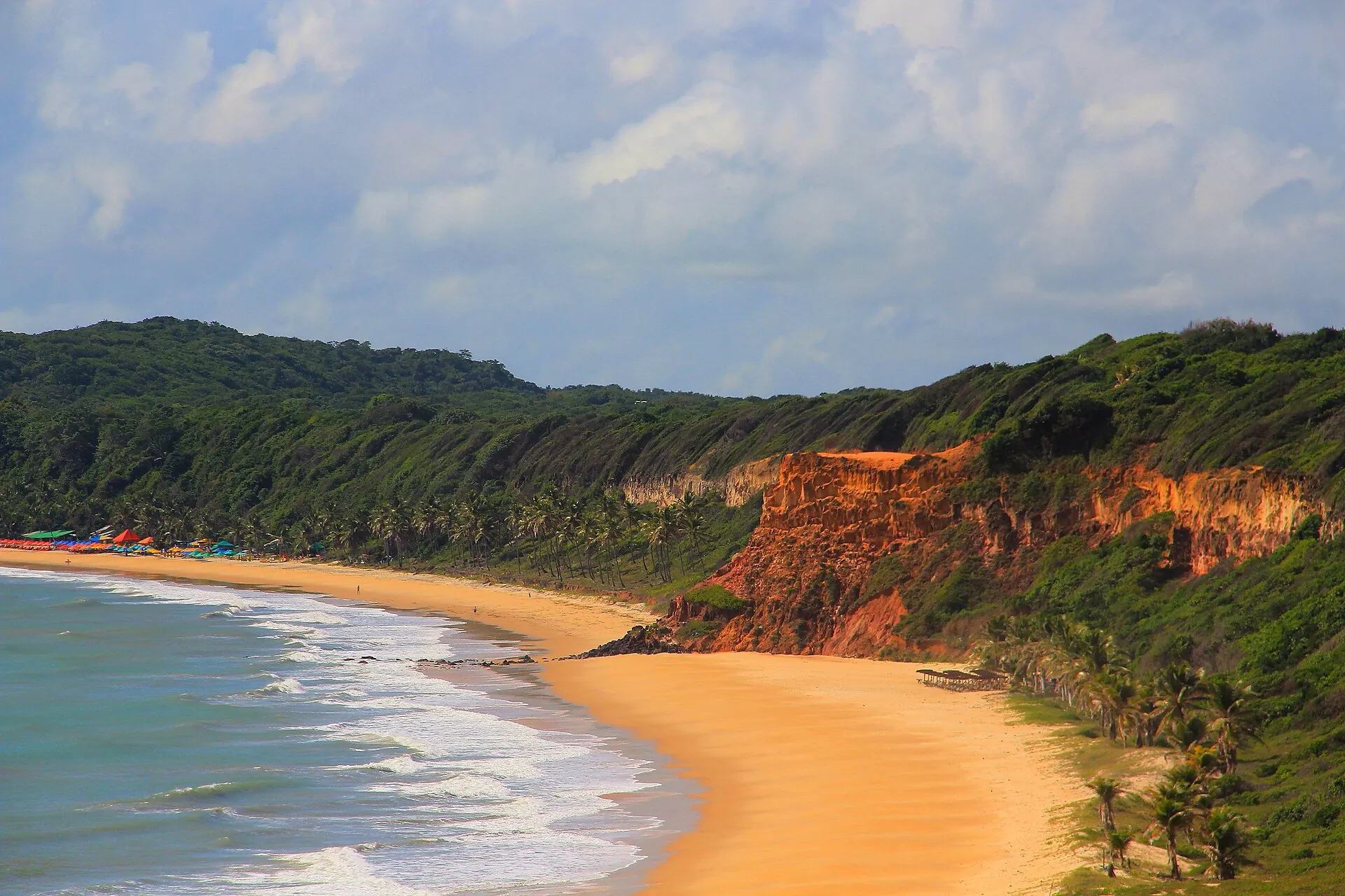 Baía dos Golfinhos, em Pipa, com falésias avermelhadas e mata no alto