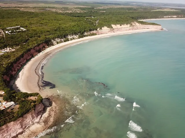 Baía dos Golfinhos vista do alto, com a faixa de areia ao pé das falésias