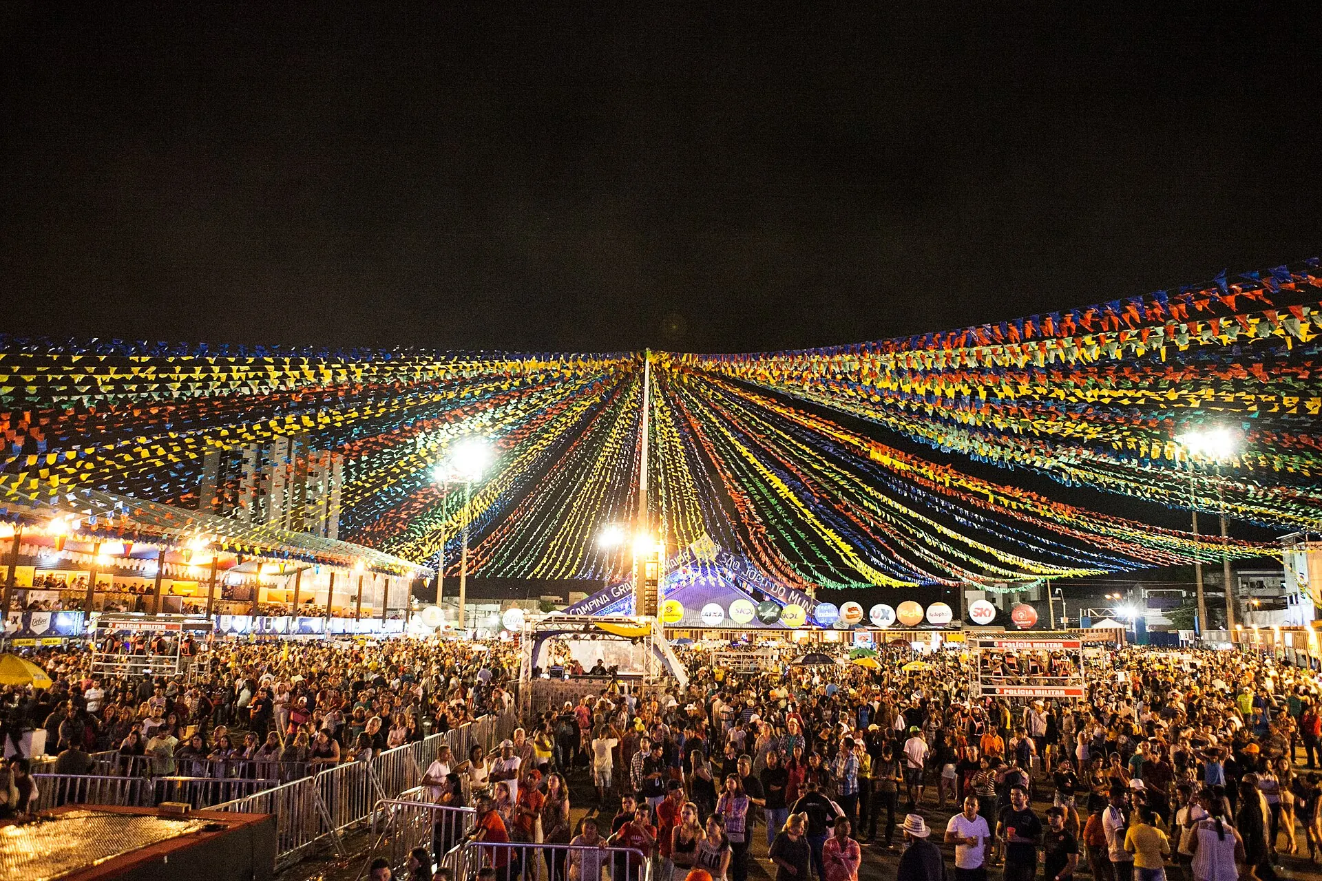 Multidão sob as bandeirinhas iluminadas do Parque do Povo, à noite, no São João de Campina Grande