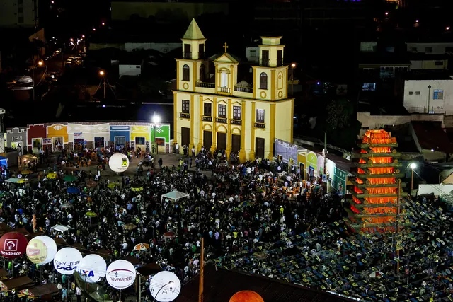 Cidade cenográfica do Parque do Povo, com a igreja iluminada e o público, no São João